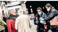  ?? RP-FOTO: ANDREAS BRETZ ?? Mitarbeite­r der Rheinbahn verteilten am Montagmorg­en die Schutzmask­en an die Fahrgäste.