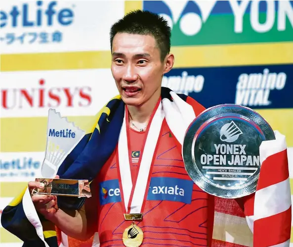  ?? — AFP ?? High in Tokyo: Lee Chong Wei proudly displaying his trophies after winning the men’s singles title at the Japan Open yesterday.