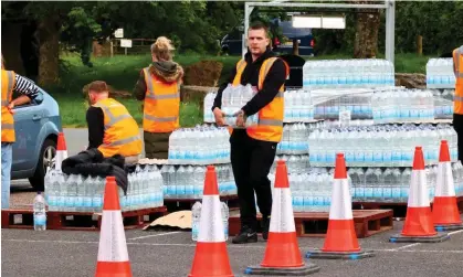  ?? Photograph: nidpor/Alamy ?? South West Water workers handing out emergency rations of bottled water to residents affected by the cryptospor­idium outbreak in south Devon last month.