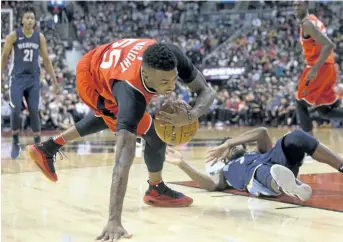  ?? CHRIS YOUNG/THE CANADIAN PRESS ?? Raptors guard Delon Wright collects a loose ball after wrestling with Grizzlies guard Wayne Selden during Toronto’s 101-86 win over Memphis on Sunday.