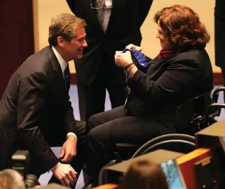  ?? VINCE TALOTTA/TORONTO STAR FILE PHOTO ?? Mayor John Tory kneels to accept the chain of office from his special guest Louise Russo at his inaugural council meeting as mayor. Russo had been paralyzed in a 2004 shooting at a North York sandwich shop.