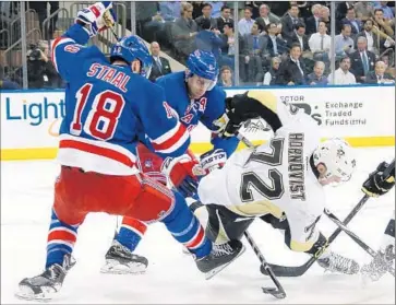  ?? Bruce Bennett Getty Images ?? MARC STAAL and Dan Girardi of the Rangers knock down Patric Hornqvist of the Penguins in first period.