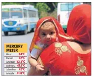  ?? MANOJ DHAKA/HT ?? A woman tries to protect her child from the scorching heat at the Rohtak bus stand on Monday.