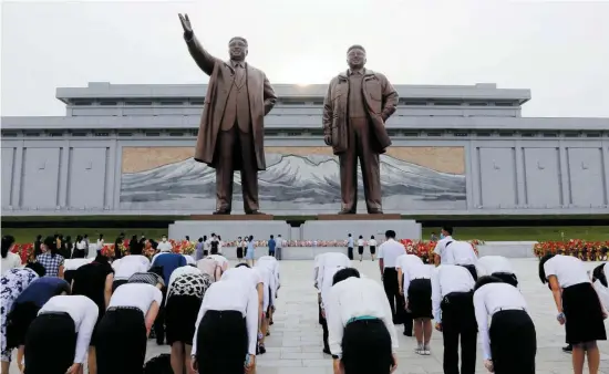  ?? FOT. CHA SONG HO / AP ?? •
Mieszkańcy Pjongjangu składają hołd pod pomnikiem prezydenta Kim Ir Sena i przywódcy Kim Dżong Ila, 7 lipca 2021 r.