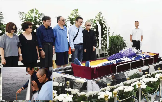  ?? — AFP photos ?? This handout photo provided by the Shenyang Municipal Informatio­n Office shows late Nobel laureate Liu Xiaobo’s wife Liu Xia (right in black) and family members standing next to Liu Xiaobo’s body at a funeral parlor in Shenyang in Liaoning province...