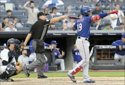  ?? BILL KOSTROUN — THE ASSOCIATED PRESS ?? Home plate umpire Ben May, center, and Texas Rangers batter Jurickson Profar, right, signal a balk by New York Yankees pitcher Dellin Betances (not shown) to score a run during the seventh inning of a baseball game Saturday at Yankee Stadium in New York.