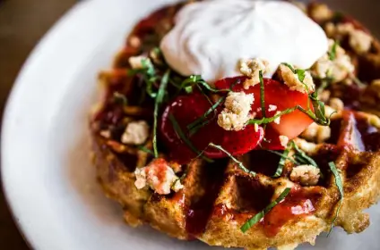 ?? Provided by Leah Mcclay, The Kitchen Restaurant Group ?? The Kitchen American Bistro's new brunch menu includes a Belgian waffle service with spiced apples, almonds and whipped cream.