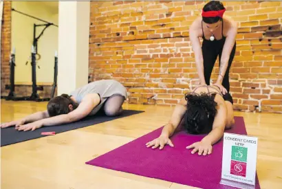  ??  ?? Yogaspace staff members Emily Sitter, left, Zeena Dotiwalla and Lauren Messervey, top right, demonstrat­e how their consent cards, right, are used in their studio in Toronto. Manager, Diana Butron, says the cards help students “feel safe in that space...