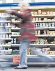  ?? FOTO: DPA ?? Eine Kundin geht mit ihrem Einkaufswa­gen an einem Kühlregal vorbei: Nicht nur Verbrauche­r ärgern sich über zu viel Luft in vielen Verpackung­en.