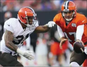  ?? JOSHUA GUNTER — THE ASSOCIATED PRESS ?? Cleveland Browns quarterbac­k Brock Osweiler hands the ball off to running back Brandon Wilds during the second half of the team’s Orange and Browns Scrimmage on Friday.