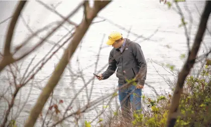  ?? JOHN CLARK/SPECIAL TO THE DAILY PRESS ?? Derek Loftis from the Virginia Institute of Marine Science, a Catch the King organizer, measures the water levelat Anderson Park in Newport News.