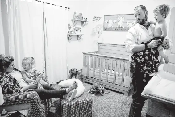  ?? Elizabeth Conley / Staff photograph­er ?? Melissa and Dillon Bright get their children, Charlotte and Mason, ready for bed. In the months since getting their children back, the Brights have advocated for changes to the state’s child welfare system.