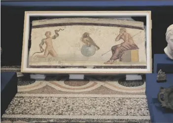  ?? ?? A Pompeiian style fresco from Herculaneu­m titled “Young Hercules and the snake,” dated to the I second A.C., is seen on display among other archaeolog­ical artifacts stolen from Italy and sold in the U.S. by internatio­nal art trafficker­s, during a press conference in Rome, on Monday.