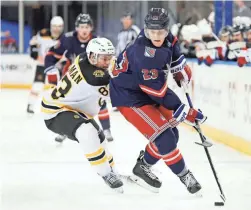  ?? SARAH STIER/AP ?? The Rangers’ Adam Fox, right, controls the puck as the Bruins’ Karson Kuhlman, left, defends during the third period on Sunday in New York.