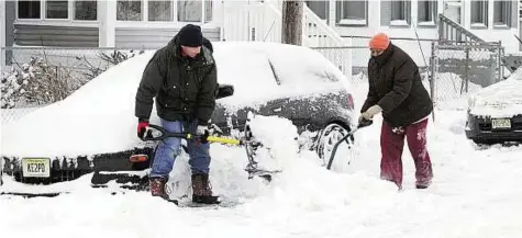 ??  ?? Making way Daryl and Pearl Johnson dig their car out of snow in front of their home off Broad Street in Pleasantvi­lle, New Jersey.
AP
