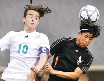 ?? DAN JANISSE ?? Altin Ibrahimi of St. Catharines Holy Cross, left, vies for the ball against James Morales of the host L’Essor Secondary School Aigles during Thursday’s action at the OFSAA soccer AA tournament in Windsor. The Aigles remained in contention for a...