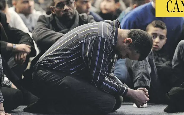  ?? PAUL CHIASSON / THE CANADIAN PRESS ?? People pray Friday during funeral services in Quebec City for three of the victims of Sunday’s shooting at the Quebec Islamic Cultural Centre. McGill law professor Daniel Weinstock says the place of Muslims in Quebec has been a recurring theme of...