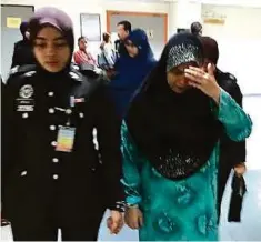  ??  ?? IRENE dibawa anggota polis selepas dijatuhi hukuman di Mahkamah Majistret Ampang, semalam.