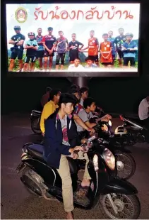  ??  ?? MOTORISTS pass a billboard with a photograph of members of the Thai children’s football team “Wild Boar” and their coach with a message “welcome home brothers” displayed in Chiang Rai as the boys and their coach were all rescued in the Tham Luang cave...