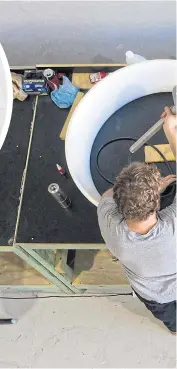  ??  ?? A staff mounts the centre body to the diffuser while manufactur­ing a Hyland 920 small wind turbine.