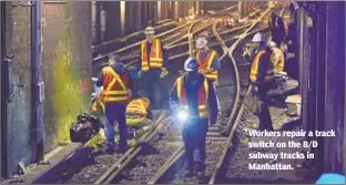  ??  ?? Workers repair a track switch on the B/D subway tracks in Manhattan.