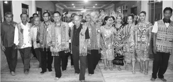  ??  ?? Nanta (front fifth left) arrives for the mangkong tiang ceremony flanked by Jamit (left) and Tuai Rumah William Unchat.