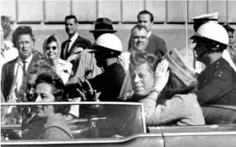  ?? AP FILE PHOTO ?? President John F. Kennedy is seen riding in his motorcade approximat­ely one minute before he was shot in Dallas on Nov. 22, 1963. In the car riding with Kennedy are his wife, Jacqueline Kennedy, and Gov. John Connally and his wife, Nellie Connally.