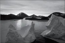  ?? ASSOCIATED PRESS ?? AN AERIAL VIEW OF LARGE ICEBERGS FLOATING Friday. as the sun rises near Kulusuk, Greenland, early