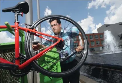  ?? DAVID BEBEE, RECORD STAFF ?? Danny Pimentel, active transporta­tion planning project manager for the City of Kitchener, uses a bike-fix station at city hall on Wednesday.