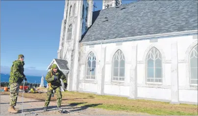  ?? CAPE BRETON POST ?? Master Cpl. Mike Dingman, left, and Master Cpl. Michael Galbiati-Bourassa of the 4 Engineer Support Regiment, Canadian Armed Forces in Gagetown, N.B., collect cable outside the former St. Alphonsus church on Tuesday. The military put a new roof on the...