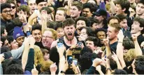  ?? NAM Y. HUH/AP ?? Northweste­rn center Matthew Nicholson, center, celebrates with fans after the Wildcats defeated Purdue 64-58 Sunday in Evanston.