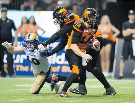  ?? THE CANADIAN PRESS/DARRYL DYCK ?? B.C. Lions’ quarterbac­k Travis Lulay, right, runs in for a touchdown as Hunter Steward blocks Winnipeg Blue Bombers’ Sam Hurl during the second half of Friday’s CFL game in Vancouver. The Lions earned a thrilling 45-42 comeback victory.