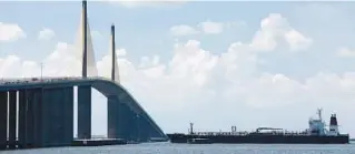  ?? DOUGLAS R. CLIFFORD/TAMPA BAY TIMES PHOTOS VIA AP ?? A tanker ship travels east under the Sunshine Skyway Bridge en route to Port Tampa Bay on July 21, 2021, in St. Petersburg. For decades, the Sunshine Skyway Bridge has been one of Tampa Bay’s most iconic landmarks. But the 190 foot-high peak has also drawn hundreds of people wanting to take their own lives.