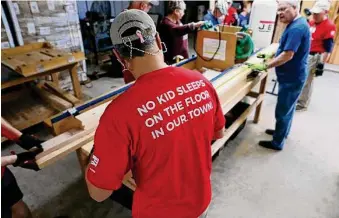  ?? Photos by Michael Wyke/Contributo­r ?? Volunteers use a special jig to cut wood the the correct length as they build bunk beds from scratch for Sleep in Heavenly Peace.