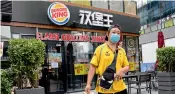  ?? AP ?? A delivery man walks out from a Burger King store in Beijing on Friday. —