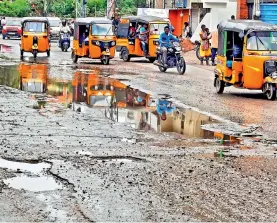  ?? — P. SURENDRA ?? A road full of potholes was further damaged due to recent rains causing problems for motorists near Amberpet in Hyderabad on Monday.
