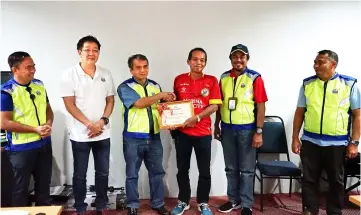  ??  ?? A KWB officer presents Kampung Giam village chief Jacob Achoi (third right) with a certificat­e of appreciati­on for participat­ing in the first external emergency drill at Bengoh Dam.