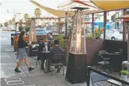  ??  ?? Owner Shirley Tan serves a drink at the Sippin’/ Bottom’s Up parklet on Mission Street in S. F.