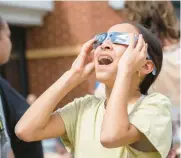  ?? SHARON MERKEL/SPECIAL TO THE MORNING CALL ?? Aahya Agrawal, 12, of Upper Saucon Township watches the solar eclipse Monday at the Promenade Shops at Saucon Valley.