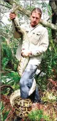  ?? ?? Easterling (left) and Bartoszek hold a 14-foot female Burmese python in March that was captured in mangrove habitat of southweste­rn Florida. Easterling holds a 15-foot female Burmese python in February in Florida.