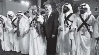  ??  ?? President Donald Trump holds a sword and smiles while joining in with traditiona­l dancers during a welcome ceremony atmurabba Palace in Riyadh on Saturday. Evan Vucci, The Associated Press