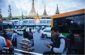  ?? BLOOMBERG PIC ?? People walking near the Sule Pagoda stupa at Maha Bandula Park in Yangon on Thursday. Almost everyone in Myanmar now has a phone with Internet service.