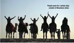  ?? ?? People pose for a photo atop camels in Mesaieed, Qatar.