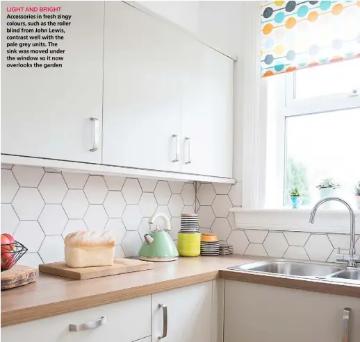  ??  ?? LIGHT AND BRIGHT Accessorie­s in fresh zingy colours, such as the roller blind from John Lewis, contrast well with the pale grey units. The sink was moved under the window so it now overlooks the garden