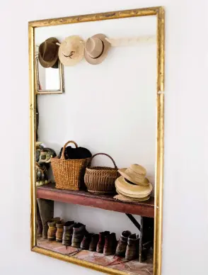  ??  ?? Accueillan­t Dans le hall d’entrée, le miroir a été chiné sur une brocante. Sur le banc et le portemante­au, collection de chapeaux et de paniers de la famille. En dessous, les chaussures de randonnée, prêtes pour partir en balade.