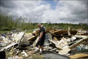  ?? BRYNN ANDERSON — THE ASSOCIATED PRESS ?? Aaron Pais kicks around debris at a mobile home park after a tornado hit on April 13 in Chatsworth, Ga.