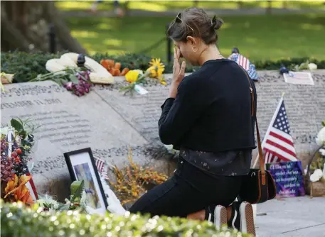 ?? pauL CoNNors / bostoN HeraLd ?? MOURNING: At the Garden of Remembranc­e in the Public Garden on Saturday, Westerly Gorayeb, right, a New York native now living in Cambridge, wipes a tear in rememberin­g her aunt Catherine Gorayeb, who was killed 20 years ago during the 9/11 terrorist attacks.