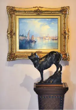 ??  ?? Thomas Moran’s Venice with a Dan Ostermille­r bronze of a wolf in front of it.