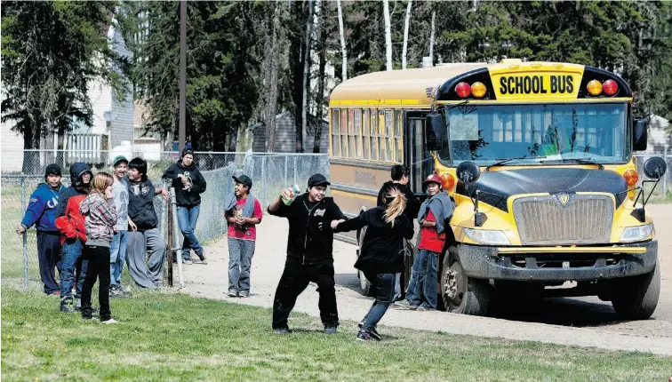  ??  ?? photos: Greg Southam , Edmonton Journal Students get ready to board a bus after school recently in Cadotte Lake, Alta., a reserve of about 800 people, 80 km east of Peace River, that’s home to the Woodland Cree Nation.