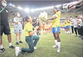  ?? — AFP photo ?? Handout photo released by the Brazilian Football Confederat­ion shows Formiga receives flowers from Brazil veteran striker Marta during her farewell match against India in Manaus.